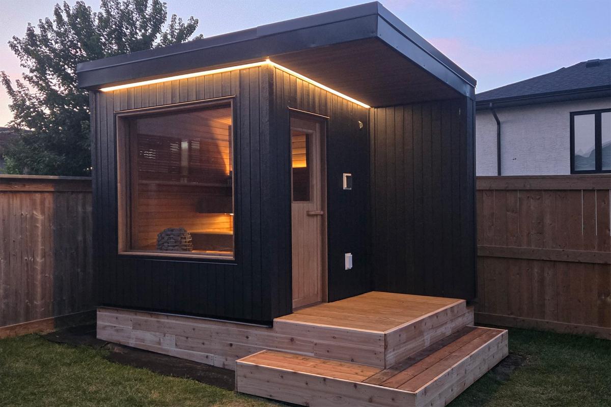 Ember Cabin exterior showing the cedar entrance door, landing, steps and recessed sauna window