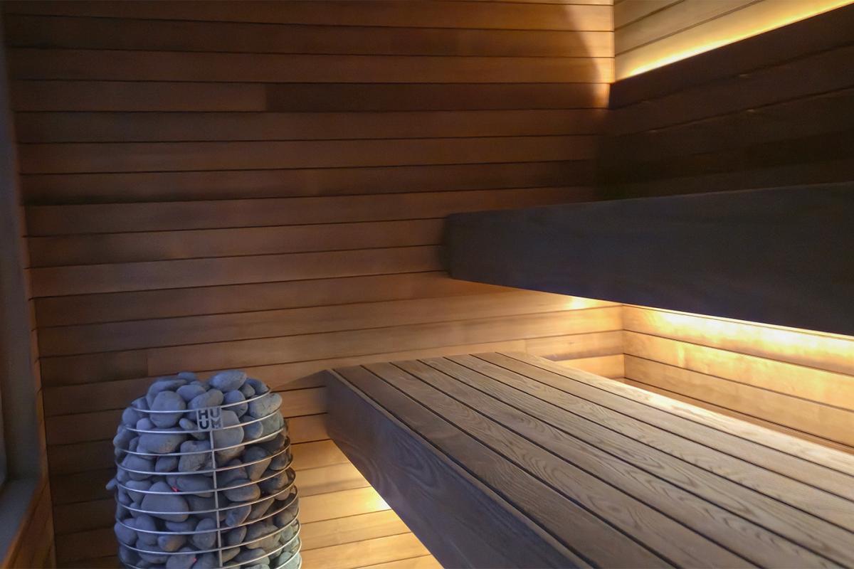 Ember Cabin sauna interior with wood benches, concealed LED lighting and a HUUM electric heater. 