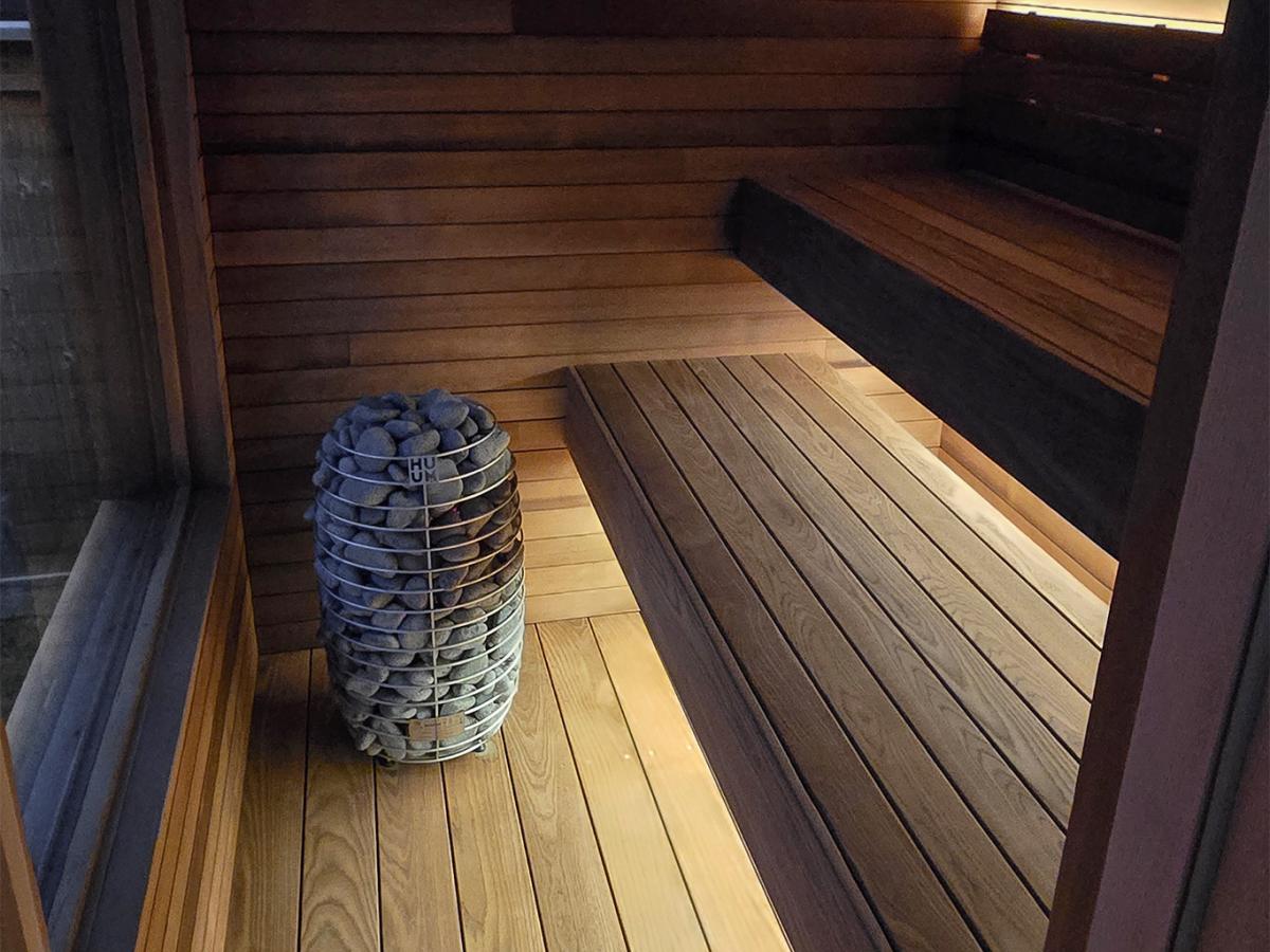 Ember Cabin interior showing two bench levels, a HUUM electric heater and wood flooring.